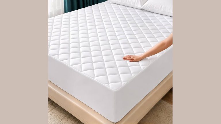 White quilted deep pocket mattress protector fitted over a tall mattress in a bright bedroom